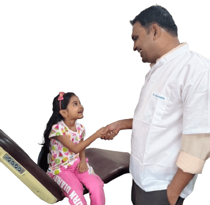 Dr. Vivek Marda greeting a young patient at Balaji Dental Clinic, Solapur